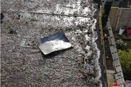 A worn felt flat roof before replacement